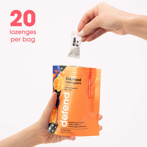 Hand holding a vitamin c drops bag with one lozenge in hand and 20 lozenges per bag copy on the image